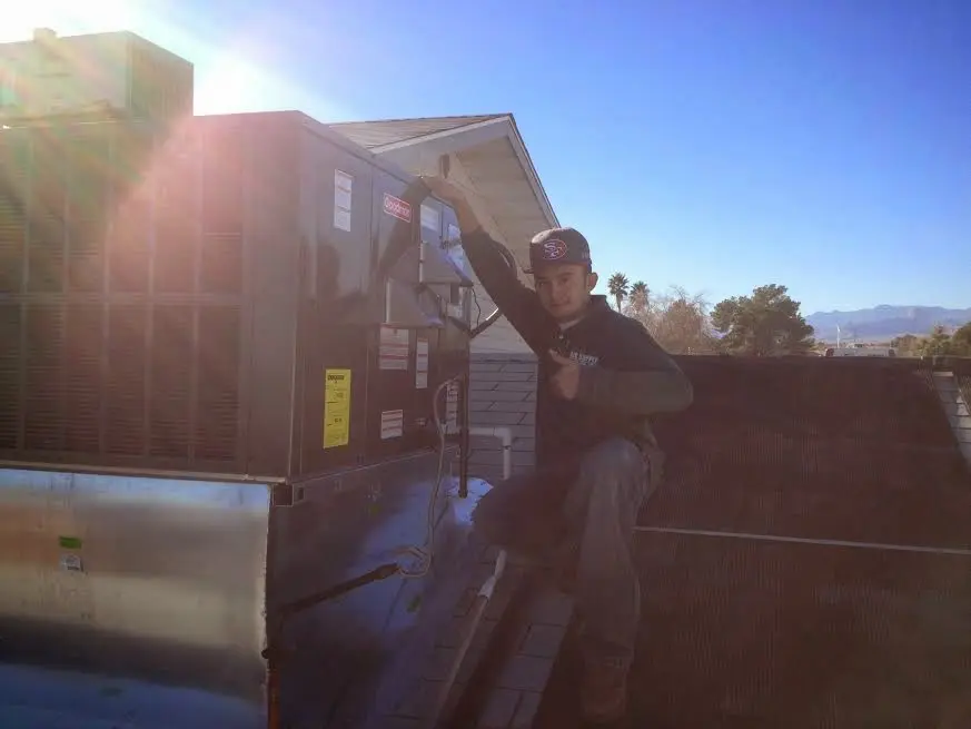 HVAC technician performing Boiler Repair on a rooftop unit in Butler